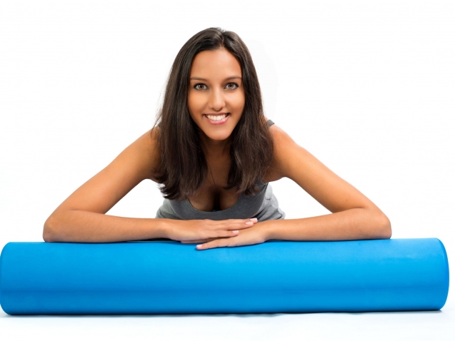 Young woman ready to do Fascia Training holding a Fascia Roll. Fascia Training describes sports activities that attempt to improve the functional properties of the muscular connective tissues.